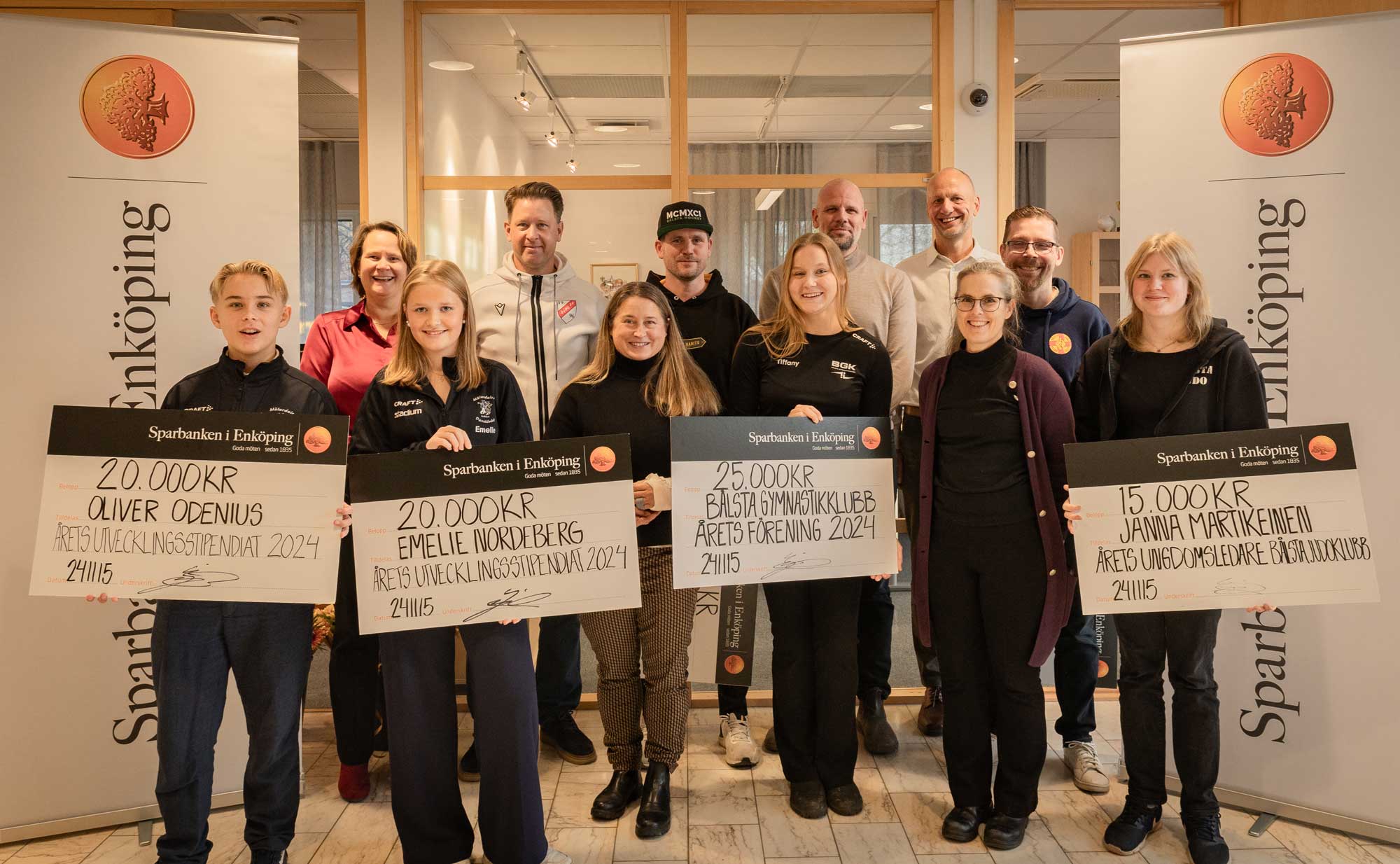 12 smiling people lookint into the camera